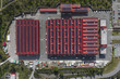 © AmazingAerialAgency - Larderello, Italy - 10 April 2026: Aerial view of Enel Green Power - Centrale Geotermica di Larderello with red rooftops covered in solar panels and surrounding industrial infrastructure.
