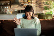 © Davor - Smiling woman on video call with laptop at home