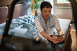© Davor - Woman checking phone after indoor cycling workout in home bedroom