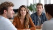 © Thares2020 - Three professionals engaged in a focused meeting discussion around a table in a modern office setting