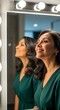 © Andres Mejia - Happy Woman Smiling at Her Reflection in a Vanity Mirror, Feeling Confident and Beautiful