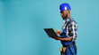 © DC Studio - Modern constructor using laptop to find inspiration for building project, browsing online and making calculations or measurements on camera. Construction worker holding wireless pc to work.