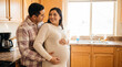 © Jian - Mother's Day pregnant woman and husband in kitchen embracing showing love daily life warmth for lifestyle magazine editorial content