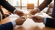 © Terry - Four business professionals' hands assembling wooden jigsaw puzzle pieces, representing teamwork and unity in strategy.
