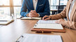 © Pamela - Business professionals in a modern office reviewing documents together.