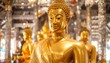© oi - Glistening golden Buddha statue, seated with others, in a blurry, decorative shrine illuminated with soft, diffused light