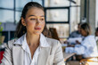 © Kostiantyn - Reflective Woman In Coworking Space. Serious Woman Engrossed In Work Amid Colleagues And Natural Light