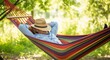 © GHM_STUDIO - Man relaxing in a colorful hammock in a lush forest. A serene scene conveying tranquility and peace. Summer relaxation, peaceful escape, vacation lifestyle.