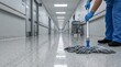© Katsiaryna - Gloved hands mopping hospital corridor floor with disinfectant in low angle perspective