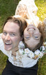 © Anna - Beautiful and happy faces of the bride and groom next to each other, looking up, top view, close-up. Couple in love, wedding, joyful moment. Emotions of happiness, love, delight, and positivity