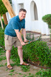 © ALEXEY - The owner of the house took pruning shears and trimmed the bushes around the building.