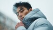 © Bargais - Asian model in a thick down jacket with a hood.