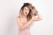 © New Africa - Unhappy woman trying to brush her tangled hair on light grey background