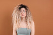 © New Africa - Unhappy woman with tangled damaged hair on brown background