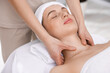© New Africa - Beautiful woman in spa headband receiving facial massage in salon, closeup
