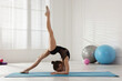 © New Africa - Cute little gymnast doing elbow stand indoors