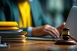 © Zabi - A lawyer works on a laptop with a gavel and stacked files in the foreground.
