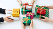 © Ejaz - Top-down view of multiple hands exchanging colorful, beautifully wrapped gift boxes on a white surface, representing community, generosity, celebration, holidays, surprise, and the joy of sharing