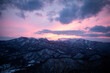 © LightItUp - Snowy mountain range under vibrant pink sunset sky