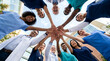© solom - diverse group of healthcare professionals and medical team stacking hands in a circle outdoors for unity cooperation success and support in front of a modern hospital building