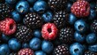 © Robbie - filling the frame, a high resolution photograph displays a large collection of ripe berries. the majority are blueberries, exhibiting their classic blue hue and rounded shape, often with a slight inde