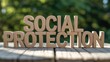 © Fahad - Wooden blocks spelling social protection on a table outdoors