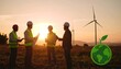 © ilyas - Group of diverse engineers discuss a project on a green field, overlooking wind turbines and a sunset. A green earth graphic is in the foreground