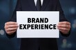 © Prazis Images - Marketing Manager Holding a Brand Experience Sign