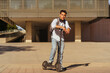 © Manu Padilla/Stocksy - Confident teenage guy wearing shirt standing on scooter