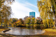 © Pietro Karras/Stocksy - Autumn city park with pond and skyline view in Boston
