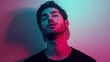 © PicAura - A young man with a relaxed expression illuminated by vibrant pink and blue lights in a studio setting.