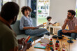 © Jovo Jovanovic/Stocksy - Family therapy session with child playing in background.