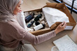 © Jovo Jovanovic/Stocksy - Woman opens box of beauty products with notebook nearby.