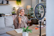 © Jovo Jovanovic/Stocksy - Woman in hijab applies makeup in front of ring light.