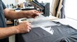 © Stitch - Worker hands peeling clear transfer film from printed graphic design on a dark t-shirt