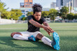 © Jovo Jovanovic/Stocksy - Black soccer player stretching on field