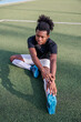 © Jovo Jovanovic/Stocksy - Young rugby player stretches on field before practice