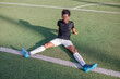 © Jovo Jovanovic/Stocksy - Soccer player stretches on the field