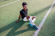 © Jovo Jovanovic/Stocksy - Smiling soccer player rests on the field