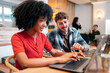 © Santi Nuñez/Stocksy - Diverse team collaborating on laptop in modern office