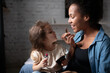 © Niyaz Tavkaev/Stocksy - Black Mother teaching multiracial daughter to apply lipstick