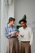 © Nuria Seguí/Stocksy - Colleagues discuss work-related topics indoors