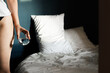 © Asya Molochkova/Stocksy - Unrecognizable Woman with Water Glass by Unmade Bed