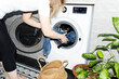 © Asya Molochkova/Stocksy - Woman Loading Clothes into Washing Machine at Home