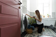 © Asya Molochkova/Stocksy - Side View Woman Checking Washing Machine Manual on Phone