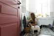 © Asya Molochkova/Stocksy - Woman Doing Laundry with Dog in Modern Bathroom