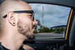 © Laura Herrera/Stocksy - Man Looking out of a Taxi Window During travel