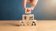 © Mary Patricia - A hand places a wooden block with a rising graph icon on a pyramid of blocks symbolizing business strategy teamwork and innovation growth success planning corporate management