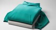 © Oja - Vibrant teal hoodie folded neatly atop a light gray garment, perfect for comfortable daily wear
