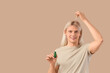 © Pixel-Shot - Young blonde man applying hair serum on beige background